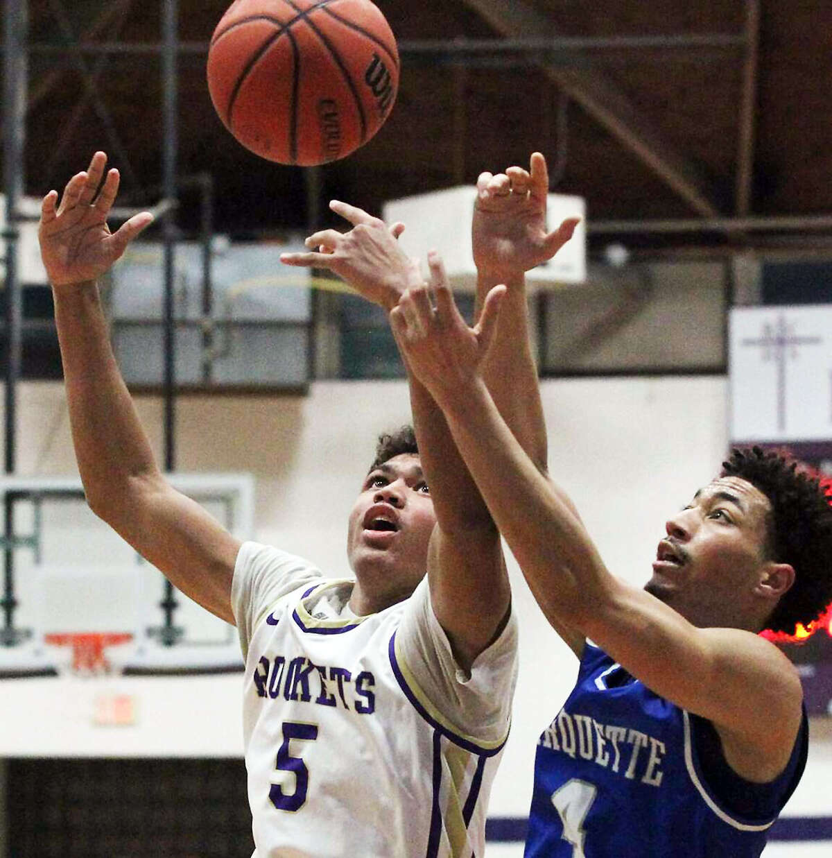 Marquette's Kendall Lavender, right, and Jacksonville Routt's Michael Wilson go for a rebound during Tuesday night's game at the Routt Dome in Jacksonville. Routt won, 54-41.