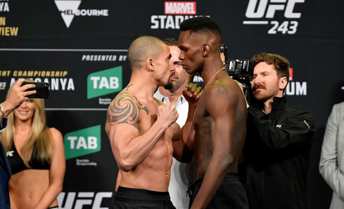 Robert Whittaker (left) and Israel Adesanya face off during the UFC 243 weigh-in at Marvel Stadium on October 05, 2019 in Melbourne, Australia. The two will have a rematch of their 2019 fight, which Adesanya won, at Toyota Center on Saturday, Feb. 12, 2022.