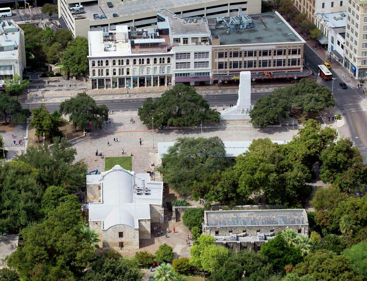 Alamo Plaza, with the Alamo in the lower left corner, is visible in this 2015 aerial photo. The white marble cenotaph is visible to the right of the image in front of three buildings belonging to the Texas General Land Office.