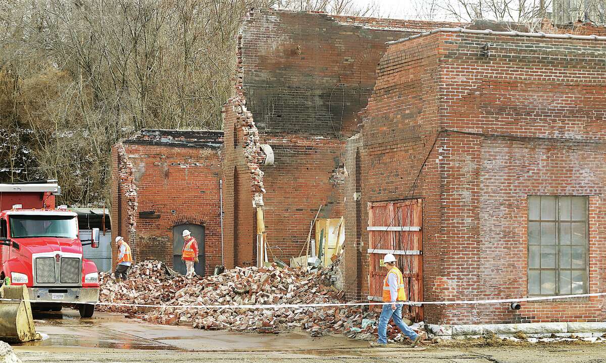John Badman|The Telegraph Workers from Stutz Excavating began tearing down 603 Piasa St. in Alton Wednesday. Constructed in the late 1890s, the building was once the studio and warehouse for Alton artist Arthur Towata who passed away in November 2019. The building had been condemned in recent years and part of the roof had already collapsed in 2014. At least two trackhoes tore down the north end of the building Wednesday and were working through the center, tearing out walls Wednesday afternoon. Caution tape surrounded the brick building, warning of an asbestos hazard at the site. Towata began using the building, which was once a street car power plant and foundry, in the 1970's. In 2016, Towata's agent, James Thompson, spearheaded an effort to salvage the one-of-a-king-art that was inside the building. A long-term goal for the building itself was to eventually make it a gallery and useable workspace once again, but those efforts appeared to have been unsucessful. In January, the Alton City Council approved a low bid of $80,800 from Stutz Excavating to tear down the building. An exhibit of Towata's art is currently ongoing at the Jacoby Arts Center, with a reception planned 6-8 p.m. Friday, Feb. 11.