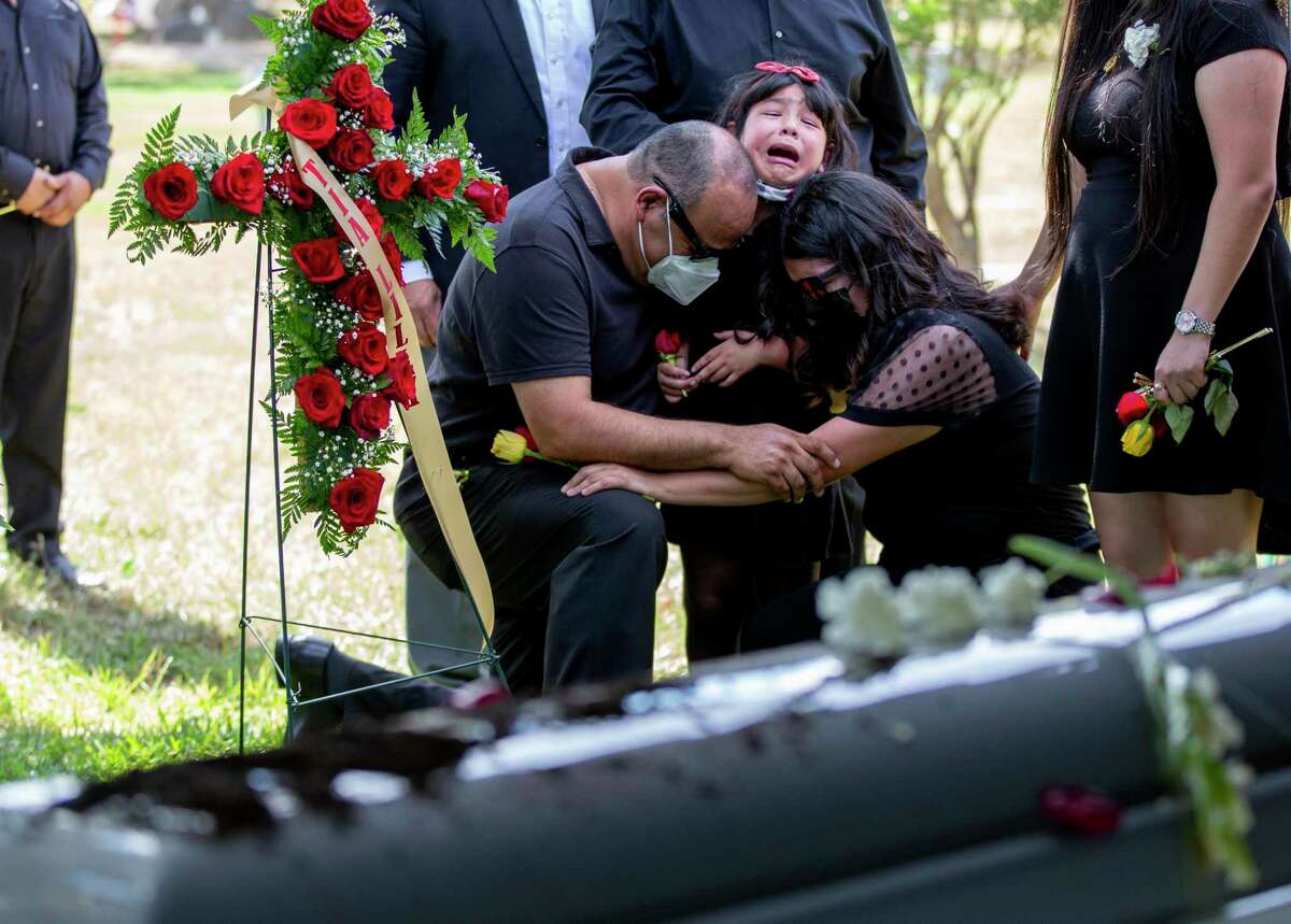 Sophia Gonzalez is embraced by her father Sergio Gonzalez and her sister Destiny Gonzalez as her mother’s coffin is lowered into the ground.