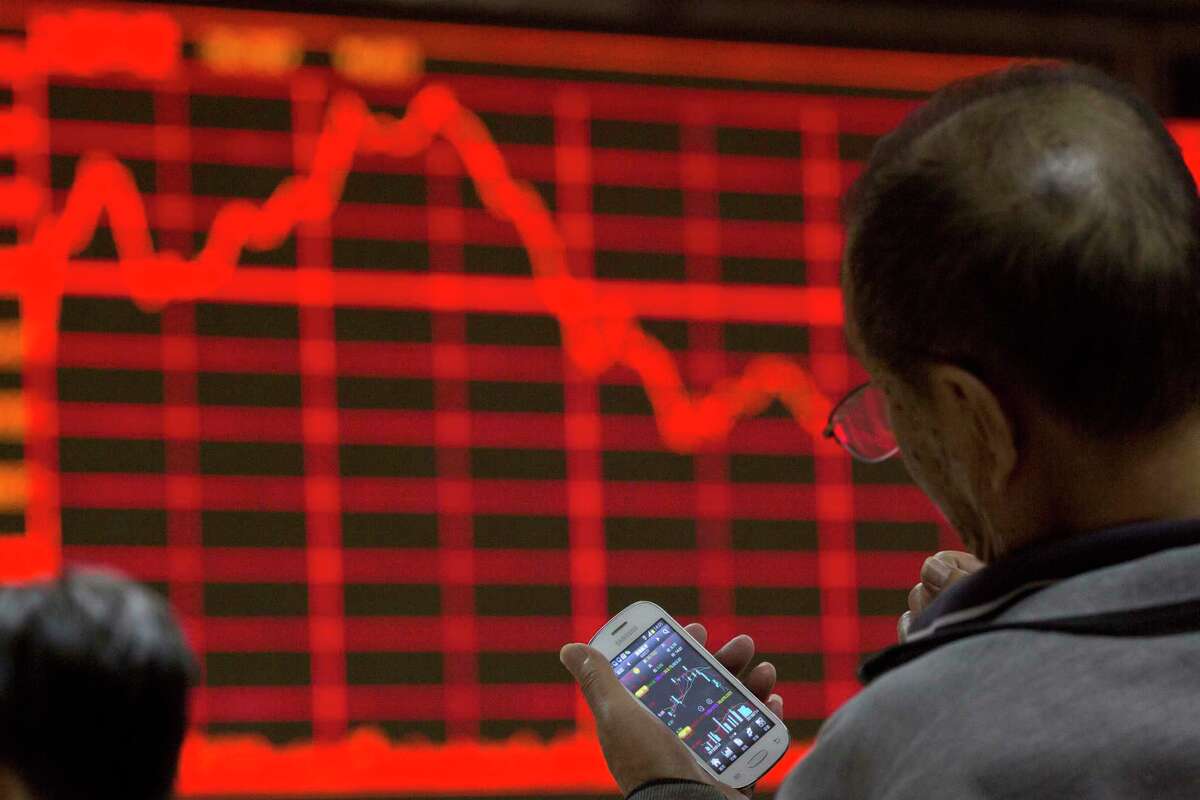An investor looks at his smart phone displaying stock prices at a brokerage in Beijing Tuesday, July 14, 2015. The Shanghai Composite Index still is down more than 20 percent from its June 12 peak. State-owned brokerages and government pension funds have pledged to buy stocks, and executives and big shareholders are barred from selling. (AP Photo/Ng Han Guan)