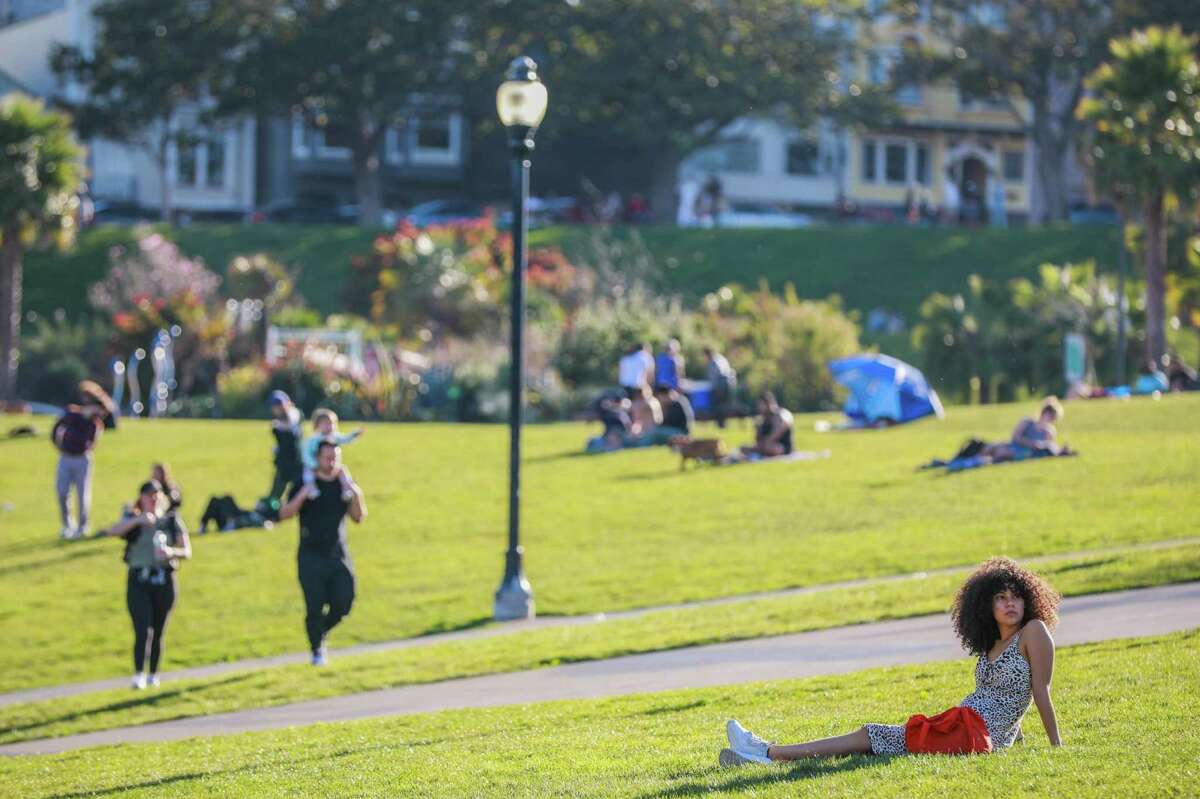 Ahja Henry relaxes lays out on the grass at Dolores Park on a warm February day in San Francisco. Temperatures across the Bay Area are expected to soar in the coming week.