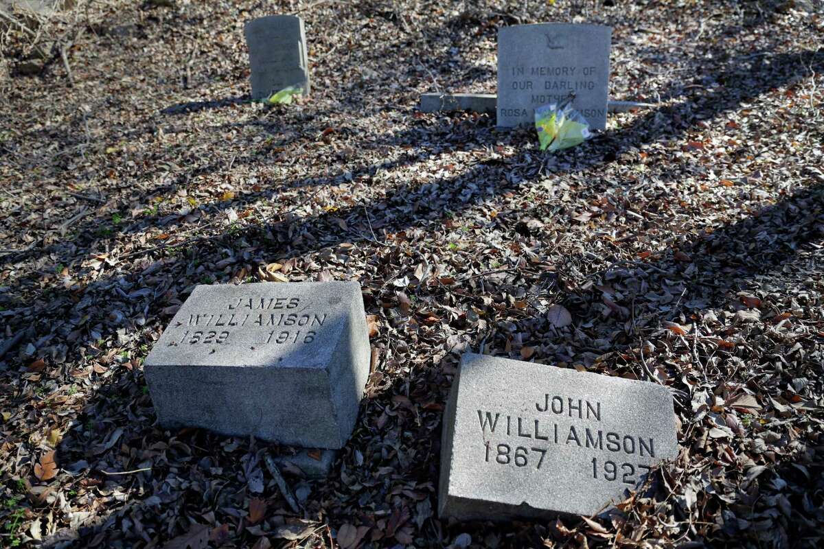 Some of the weed and leaf covered graves in the Williamson family plot in the northeast section of the historically black Olivewood cemetery Saturday, Feb. 5, 2022 in Houston, TX. Some five volunteers spent the morning weed whacking, raking leaves and doing general clean up across the cemetery.