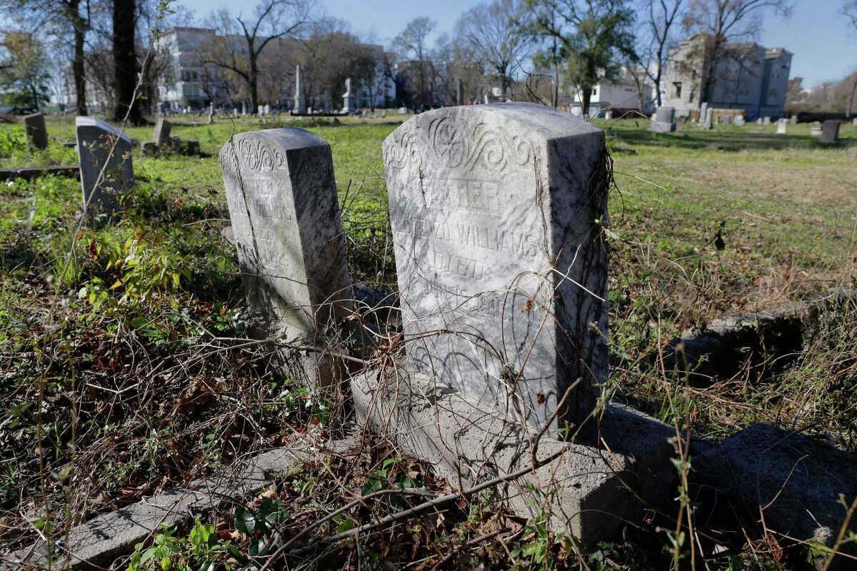 Some of the overgrown headstones in the Williams family plot in the northeast section of the historically black Olivewood cemetery Saturday, Feb. 5, 2022 in Houston, TX. Some five volunteers spent the morning weed whacking, raking leaves and doing general clean up across the cemetery.