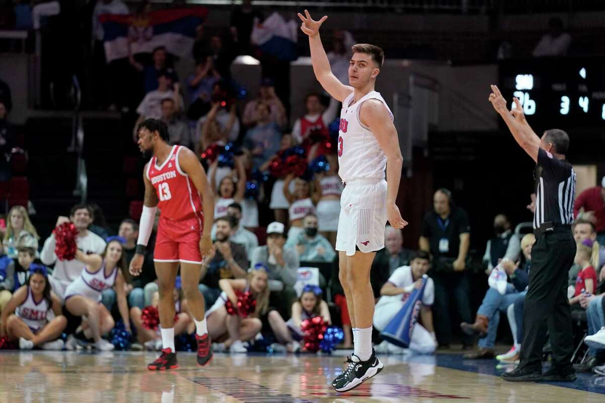 SMU forward Stefan Todorovic celebrates sinking a three-point basket in front of Houston's J'Wan Roberts, left rear, in the first half of an NCAA college basketball game in Dallas, Wednesday, Feb. 9, 2022. (AP Photo/Tony Gutierrez)