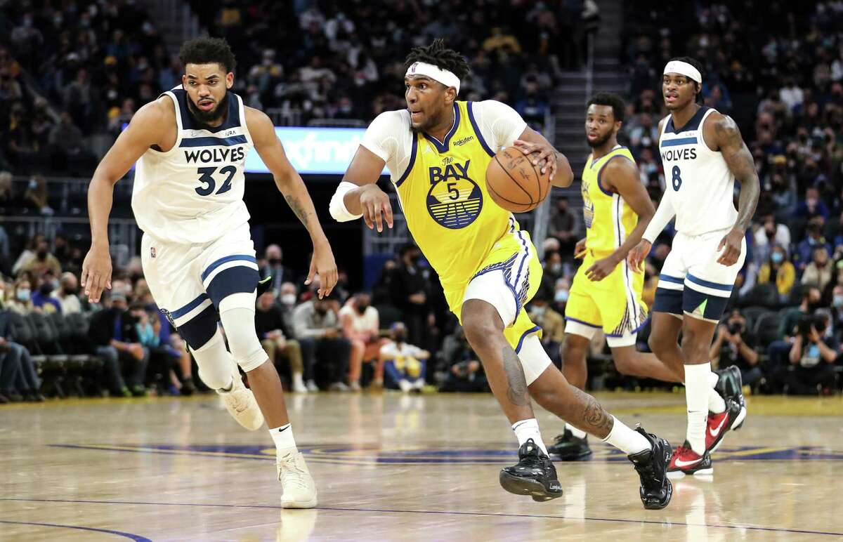 SAN FRANCISCO, CA - JANUARY 27: Kevon Looney #5 of the Golden State Warriors dribbles up the court with the ball against Karl-Anthony Towns #32 of the Minnesota Timberwolves at Chase Center on January 27, 2022 in San Francisco, California. NOTE TO USER: User expressly acknowledges and agrees that, by downloading and or using this photograph, User is consenting to the terms and conditions of the Getty Images License Agreement. (Photo by Kavin Mistry/Getty Images)