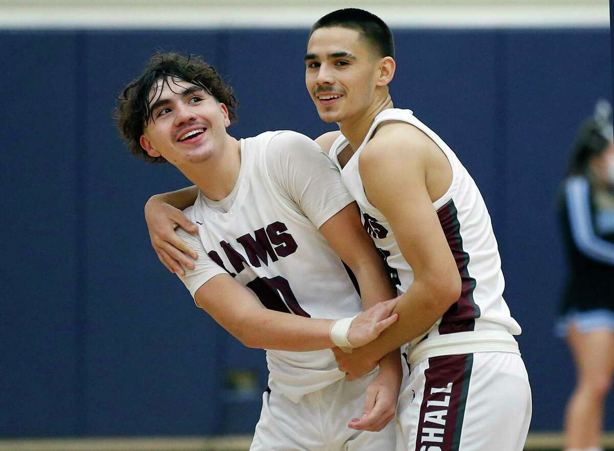 Marshall’s Luke Gonzalez (11) celebrates with teammate Matthew Gonzalez (10) in closing minute of second overtime on Wednesday, Feb. 9, 2022 at Taylor Field House. Marshall defeated Harlan 67-61 in double overtime.