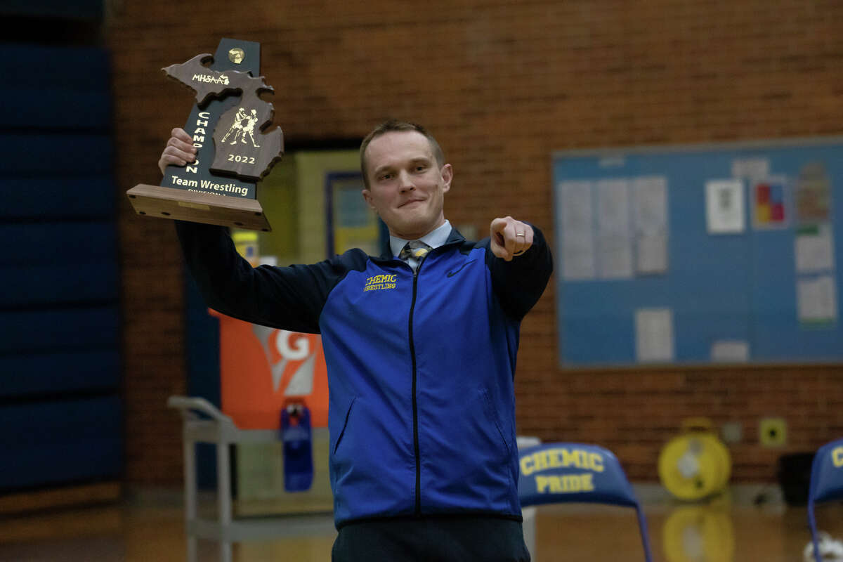 Midland High wrestling coach Mike Donovan points to his team after their 52-27 district championship victory over Dow Wednesday, Feb. 9, 2022 at Midland High School.