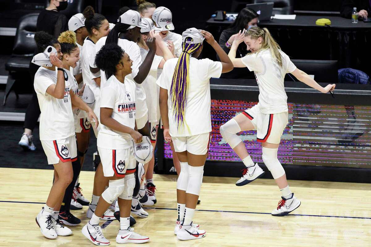Connecticut's Paige Bueckers, right, dances over to teammates while celebrating an NCAA college basketball game win in the Big East tournament finals against Marquette at Mohegan Sun Arena, Monday, March 8, 2021, in Uncasville, Conn. (AP Photo/Jessica Hill)