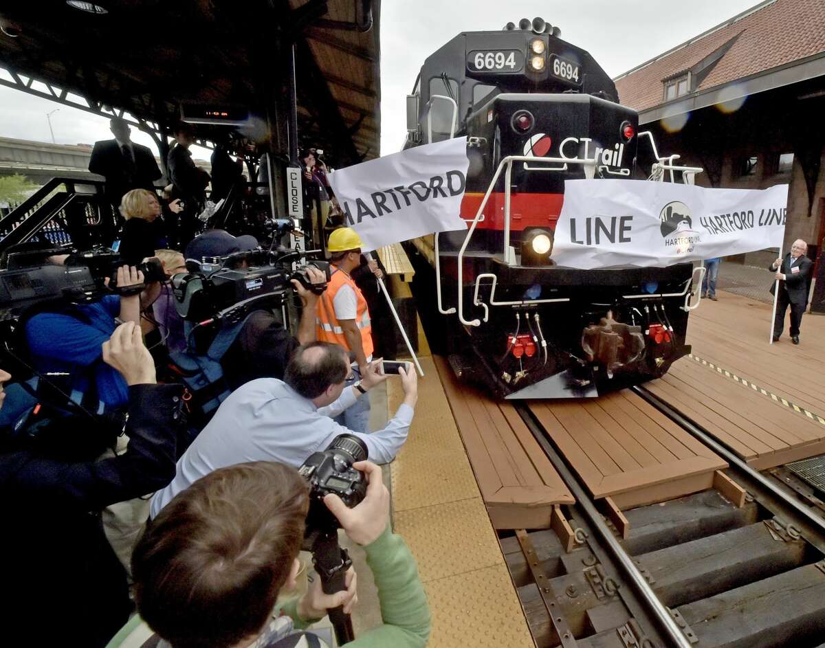 The CTrail Springfield train arrives in Hartford, breaking a paper banner heralding the inaugural run of the new CTrail Hartford Line Connecticut Rail commuter service launched in June with frequent train service between New Haven, Hartford and Springfield.