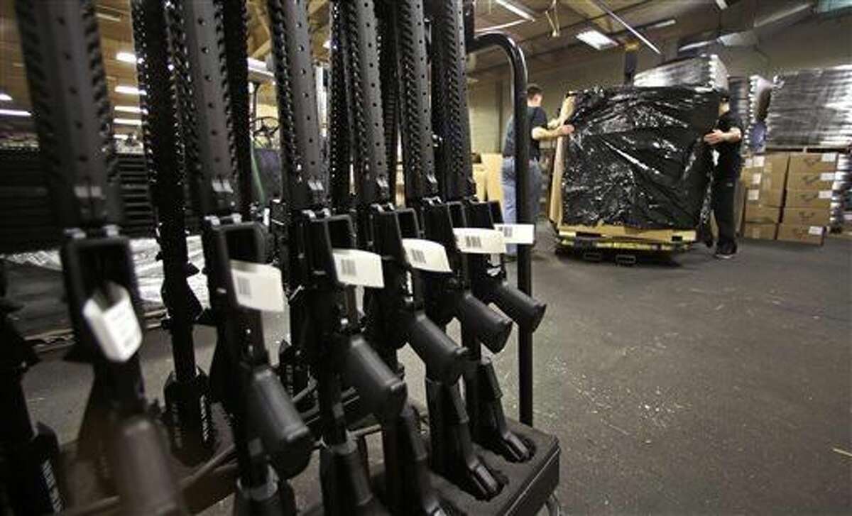 A rack of AR-15 rifles stand to be individually packaged as workers move a pallet of rifles for shipment at the Stag Arms company in New Britain, Conn., Wednesday, April 10, 2013. A Connecticut gun-maker announced on Wednesday it intends to leave the state, just six days after passage of restrictive gun control legislation, while another manufacturer, Stag Arms, which employs about 230 workers, says its customers are urging it to "pick up and leave." (AP Photo/Charles Krupa)