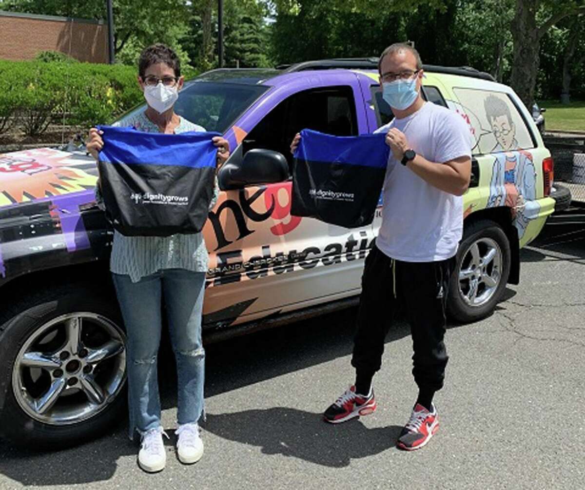 Jessica Zachs of Dignity Grows and Sammy Vega of Charter Oak Boxing Academy display Dignity Packs that will be distributed to community members in need through the boxing club located in the Parkville section of Hartford.
