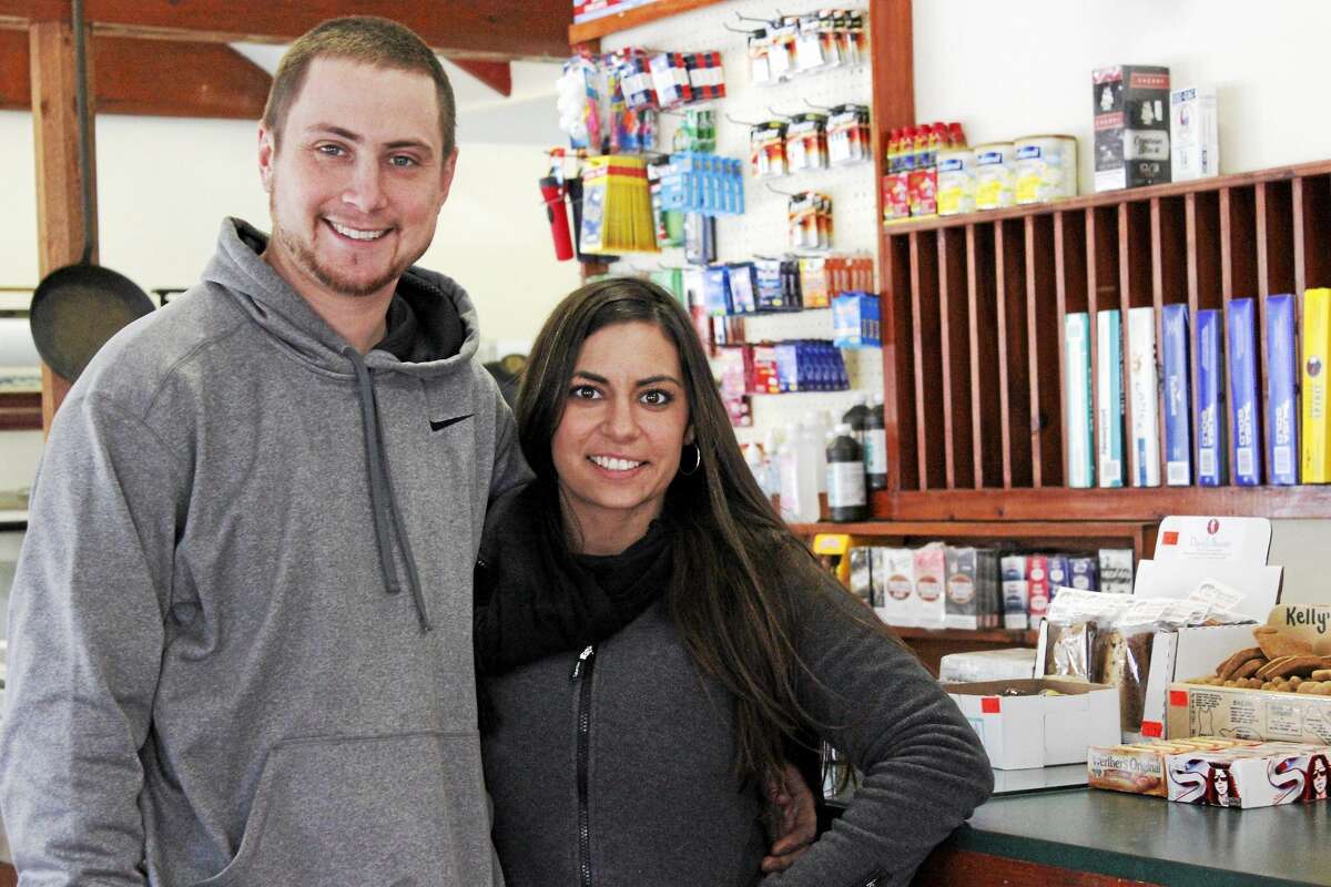 Ryan Craig and Natasha Travieso are busy preparing to open the store on Friday. (Shako Liu/The Register Citizen)