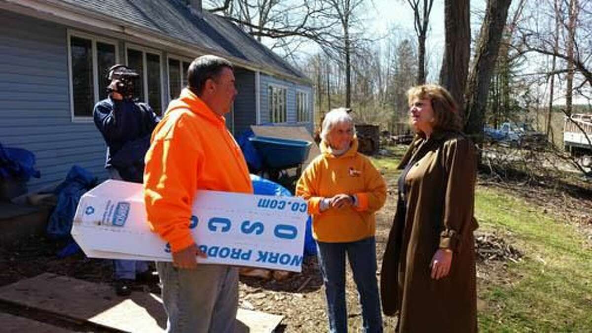 Tom Voytek, project manager of Waterbury roofing company Heritage Systems, talks with Ceia Webb, executive director of Rebuilding Together Litchfield County, and State Rep. Cecilia Buck-Taylor, R-67th House District, in front of the home of New Milford resident Debbie Marquardt on Saturday.