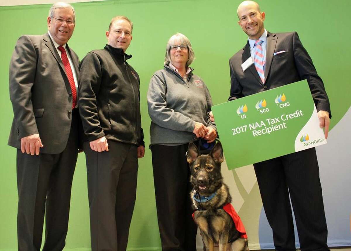 Richard LoPresti, left, and Al Carbone, right, of AVANGRID, congratulate Mark McGrath, Susan Greer and canine Olive of the Fidelco Guide Dog Foundation after presenting a check for $4,641.99 to help the nonprofit with energy-efficient lighting upgrades.