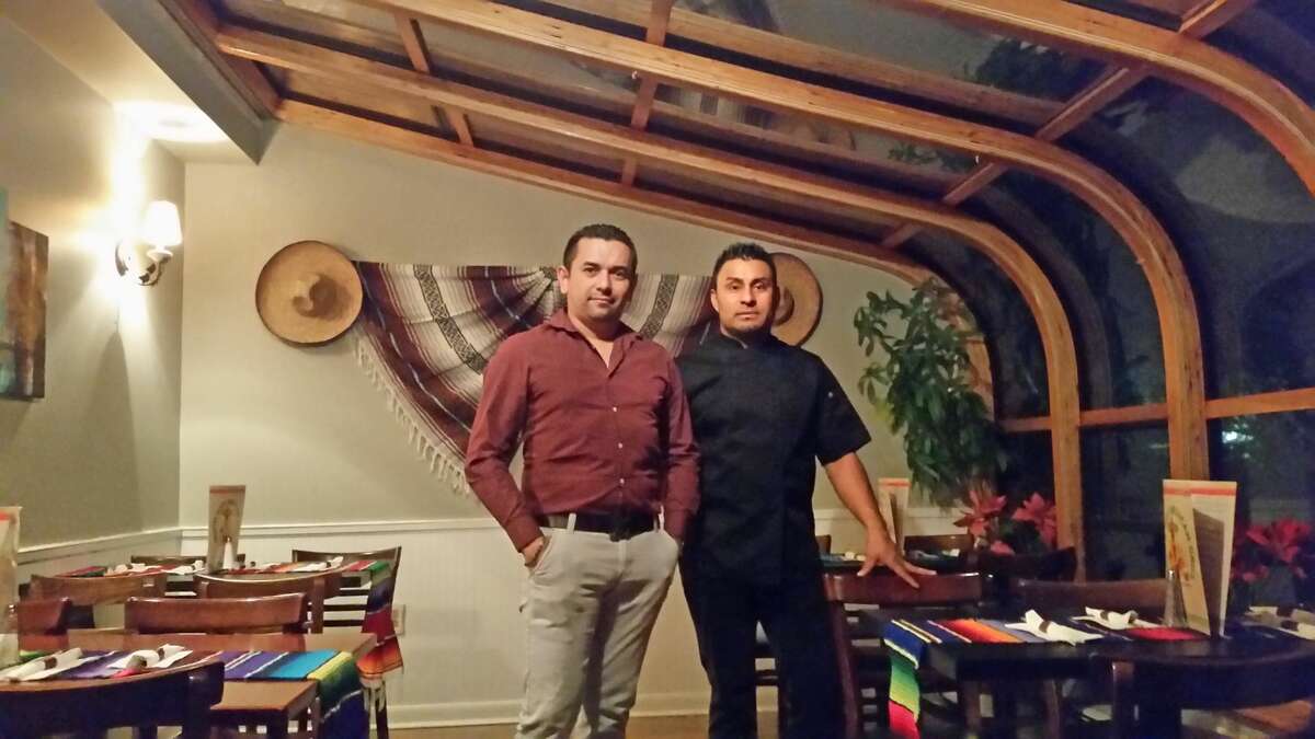 General manager Jose Reyes, left, and manager Fernando Galicia take a break on a busy night at Picante’s in the wrap-around skylight porch room.