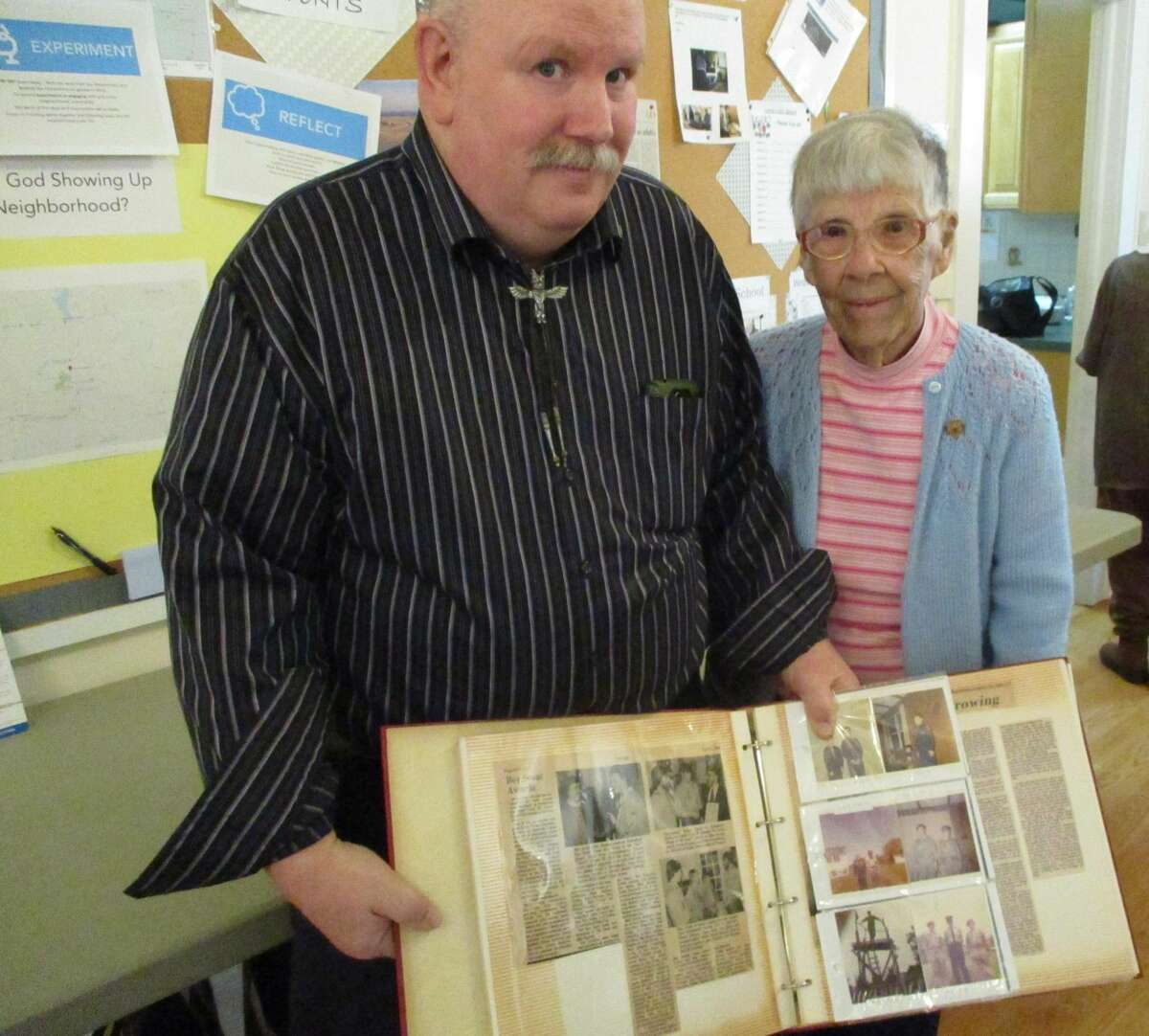 David Maddox, Senior Warden of Christ Church, and his mother Evelyn Maddox, display one of her scrapbooks from her days as a girl scout.