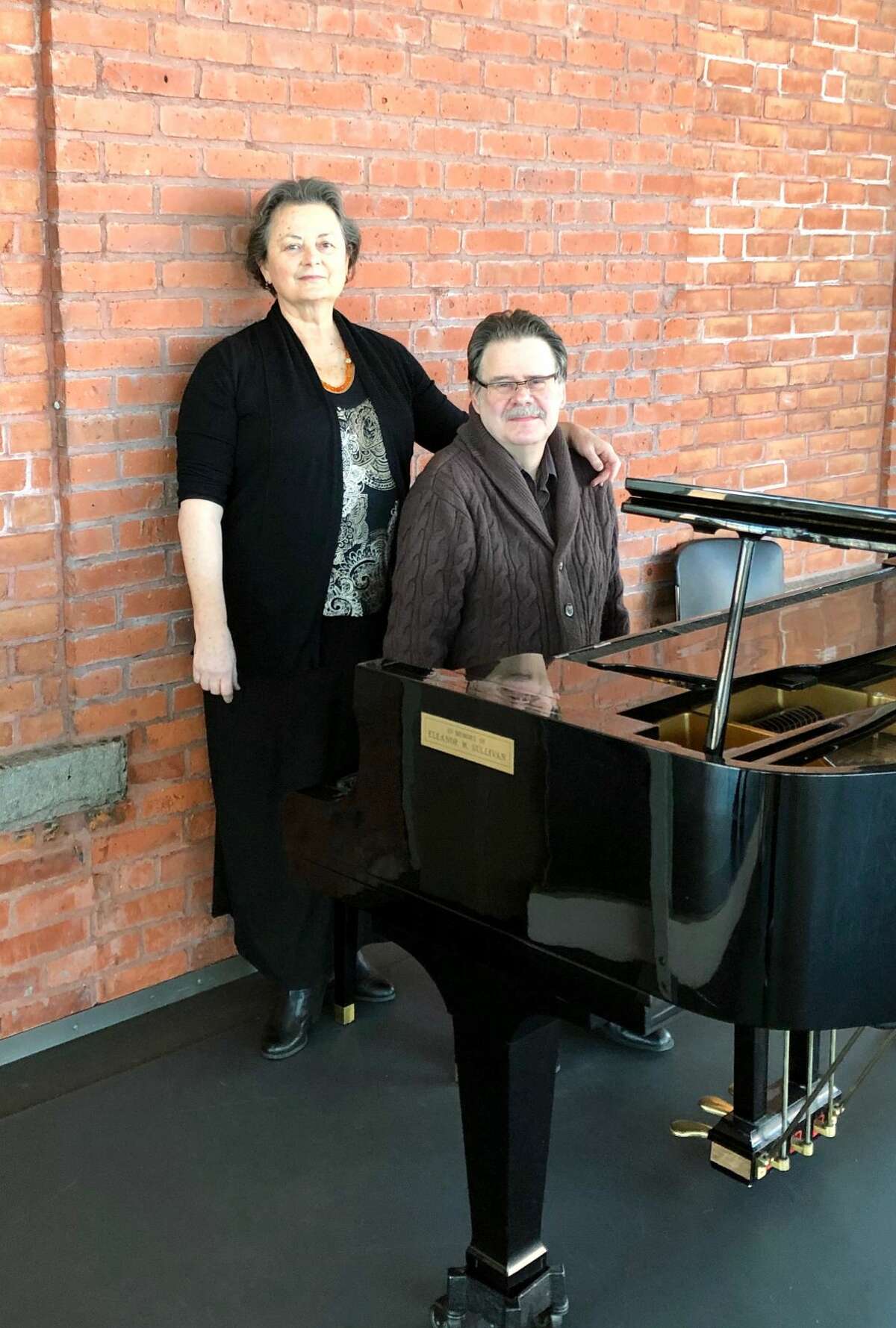 Denise Warner Limoli and Michael Limoli pose at a studio piano at the Nutmeg Conservatory for the Arts.