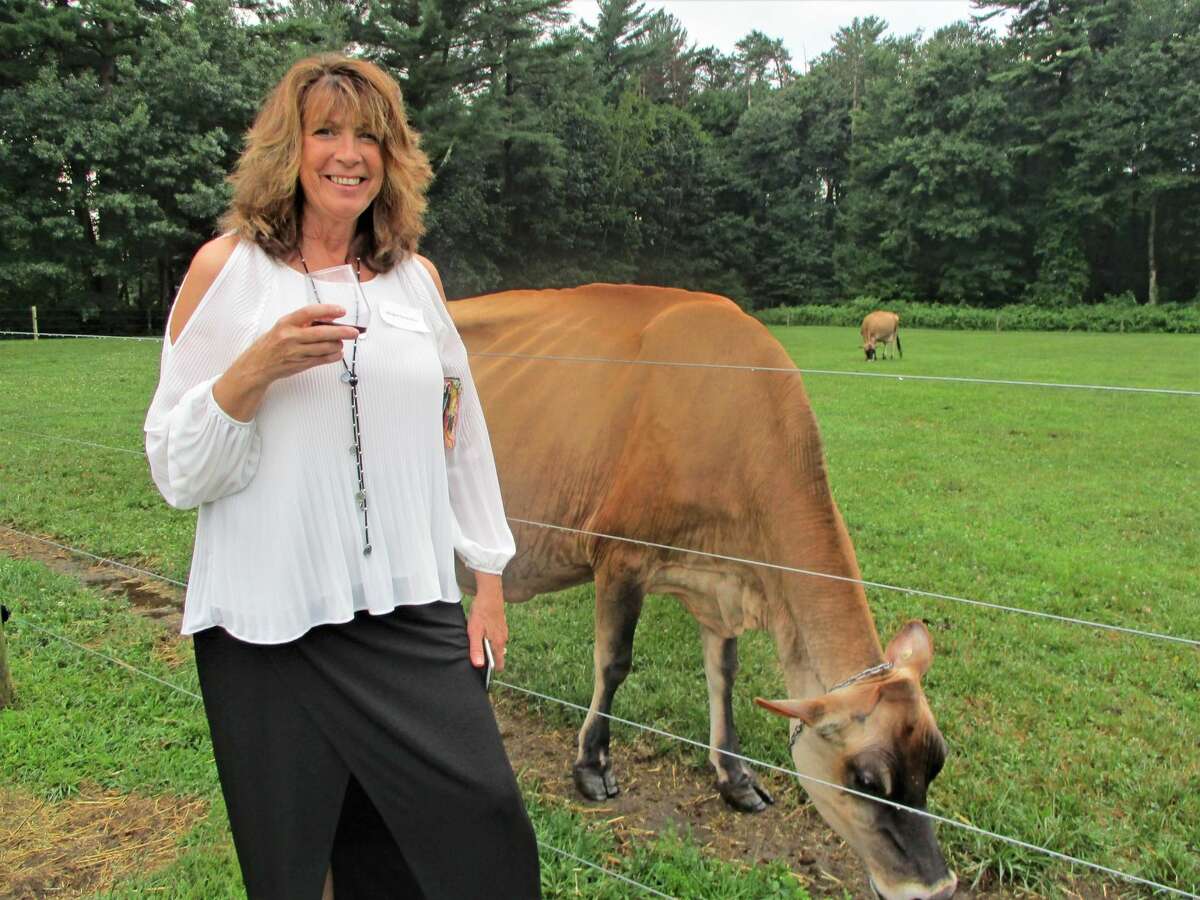 Brenda Delaney of Northfield felt at home petting one of the prize-winning Arethusa cows since she and her young children lived on the Farnum farm in Morris.