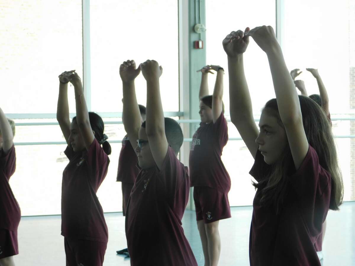 Students from St. John Paul the Great Academy practice stretching exercises at Nutmeg Ballet Conservatory, part of a 10-week collaborative outreach program between the two organizations.