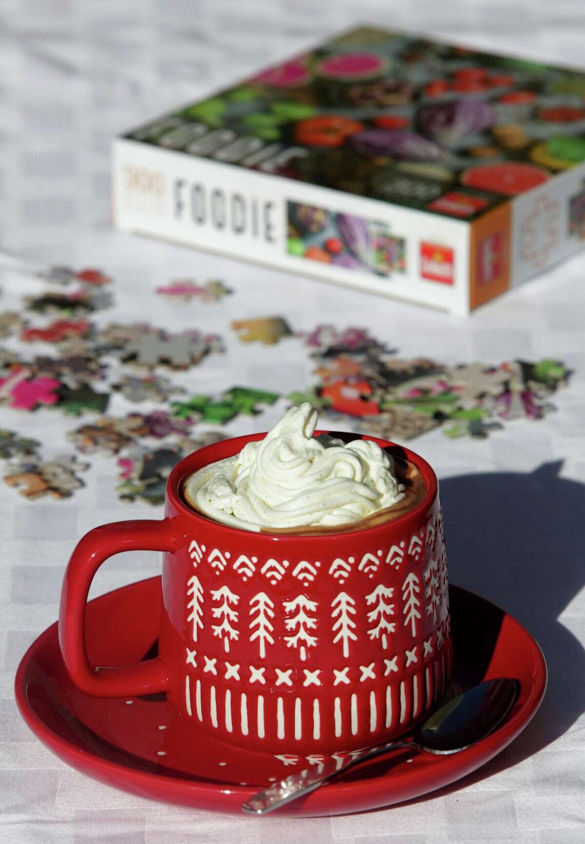 Hot chocolate, like this Parisian Hot Chocolate, topped with Chantilly whipped cream, is an ideal beverage to sip on a cold winter's night while working a jigsaw puzzle.