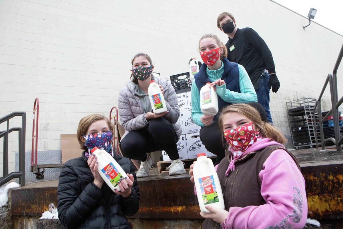 From left, Olivia Hall, Allie Davenport, Maddie Hall, Cwen Cole and others supply free milk to those in need.