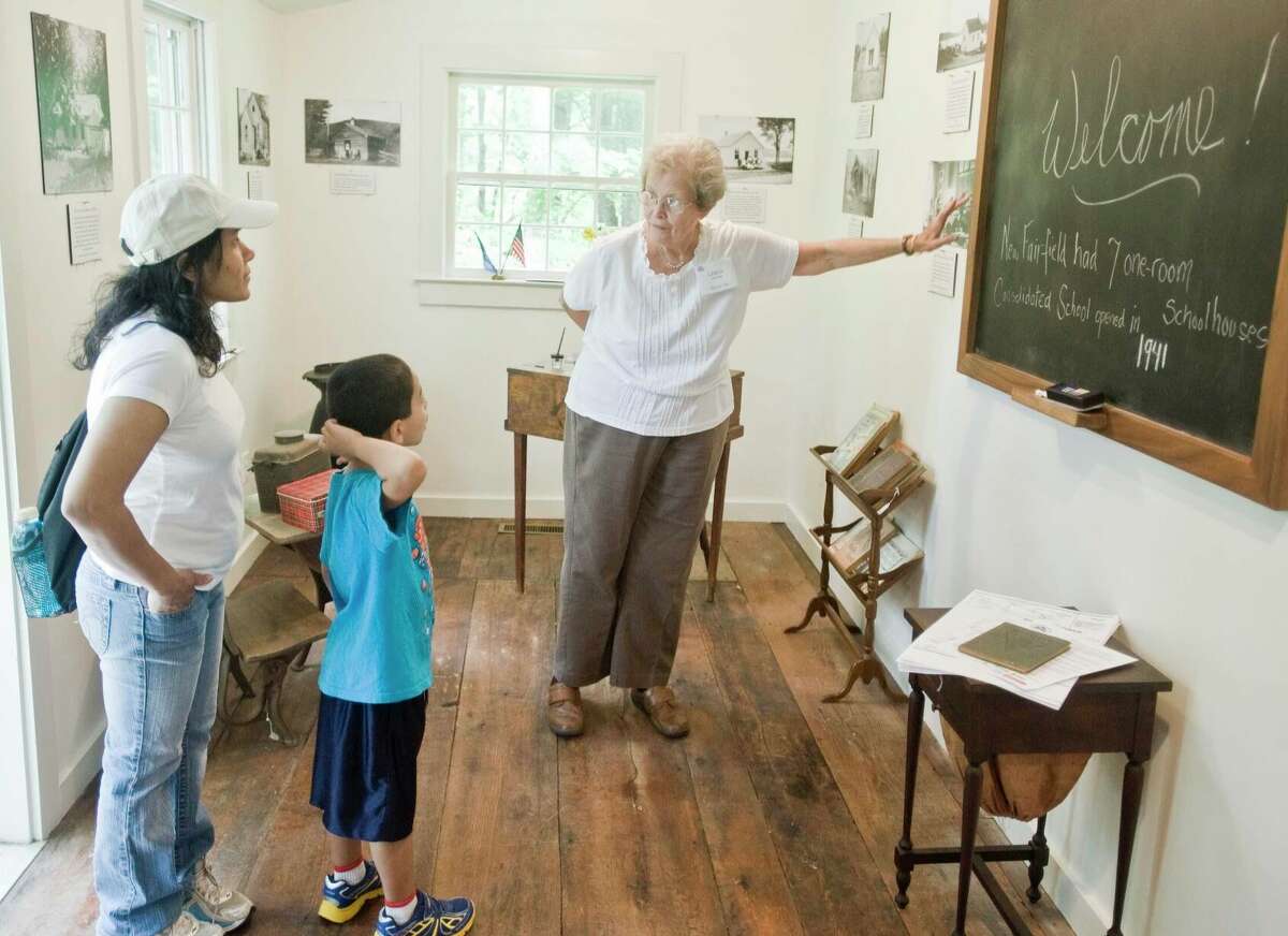 Volunteer Linda Decker, of New Fairfield, describes a blackboard from a one-room schoolhouse once located in town in 2016.