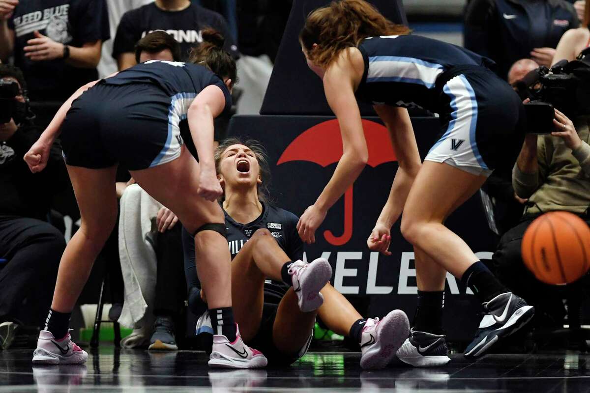 Villanova's Bella Runyan, center, reacts to being fouled with teammates Villanova's Brianna Herlihy, left, and Villanova's Maddy Siegrist, right, in the first half of an NCAA college basketball game against Connecticut, Wednesday, Feb. 9, 2022, in Hartford, Conn. (AP Photo/Jessica Hill)
