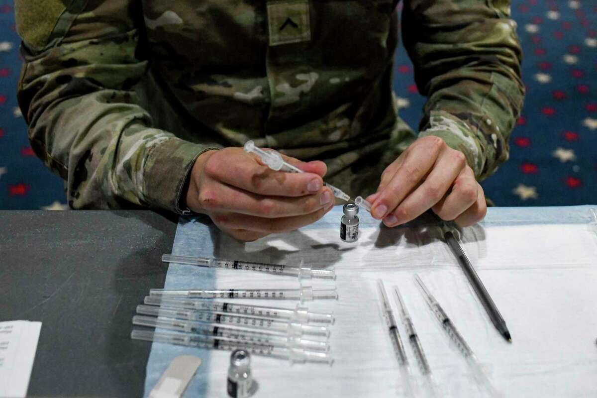 FILE ?‘ A soldier prepares vaccine doses for administration at Fort Bragg, N.C., Feb. 24, 2021. American soldiers who have yet to be vaccinated against the coronavirus will be immediately discharged, the Army said on Wednesday, Feb. 2, 2022, joining other branches of the military, including the Air Force, that have already begun dismissing vaccine holdouts. (Kenny Holston for The New York Times)