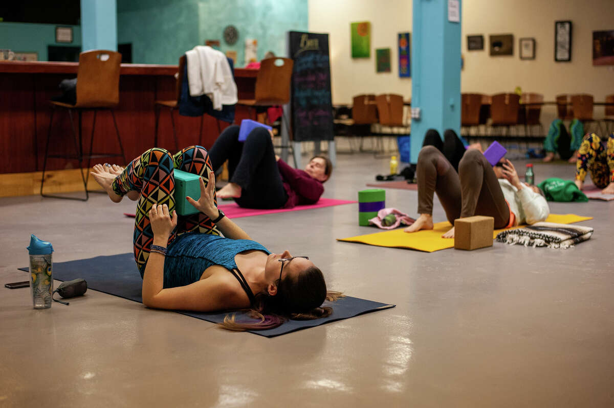 Yoga instructor Sarah Nelson (left) leads a yoga class during the Happy Hour Yoga event on Feb. 9, 2022 at Mi Element Grains & Grounds. The event is held monthly at the micro brewery and coffee shop.