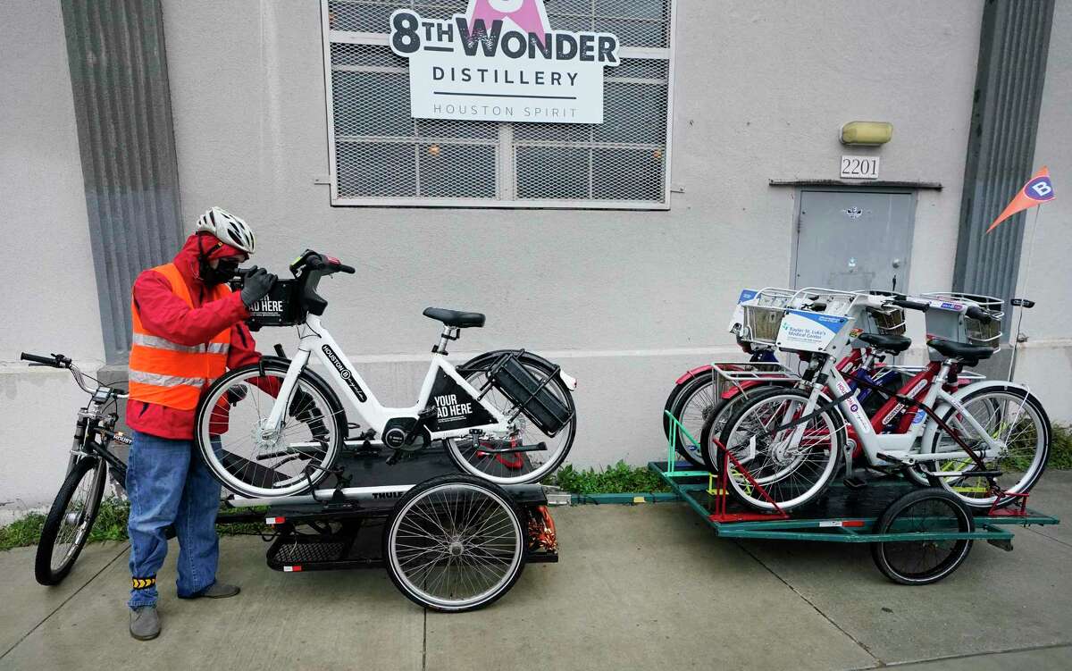 Ian Freeman, an e-trike operator, collects bicycles at the 8th Wonder BCycle station Thursday, Feb. 3, 2022 in Houston. BCycle, the city's bike share program, uses the e-trike, a three wheel pedal-assisted cycle, along with a trailer to move bikes between stations.