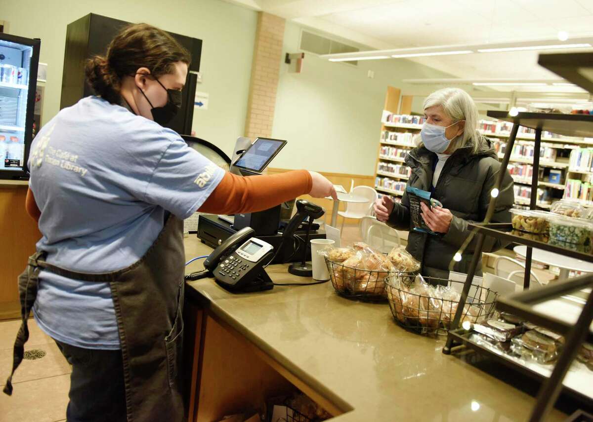 Cafe employee Melanie Luchetta rings up library employee Pat Sheary at The Cafe at Darien Library in Darien, Conn. Monday, Feb. 7, 2022. The cafe, which employs special needs adults from local nonprofit Abilis, has been open in a soft launch format since November but will have its official grand opening with First Selectman Monica McNally this Wednesday at 11 a.m.