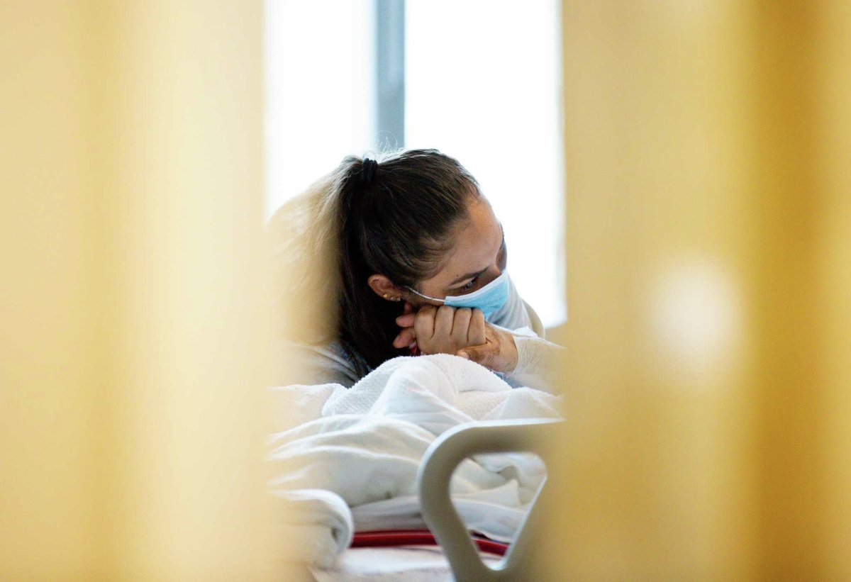 Perla Munguia looks at her husband, Jesus Ceja Ceja, intently as she visits him at Houston Methodist Hospital. Jesus has been at this hospital on life support for a month.