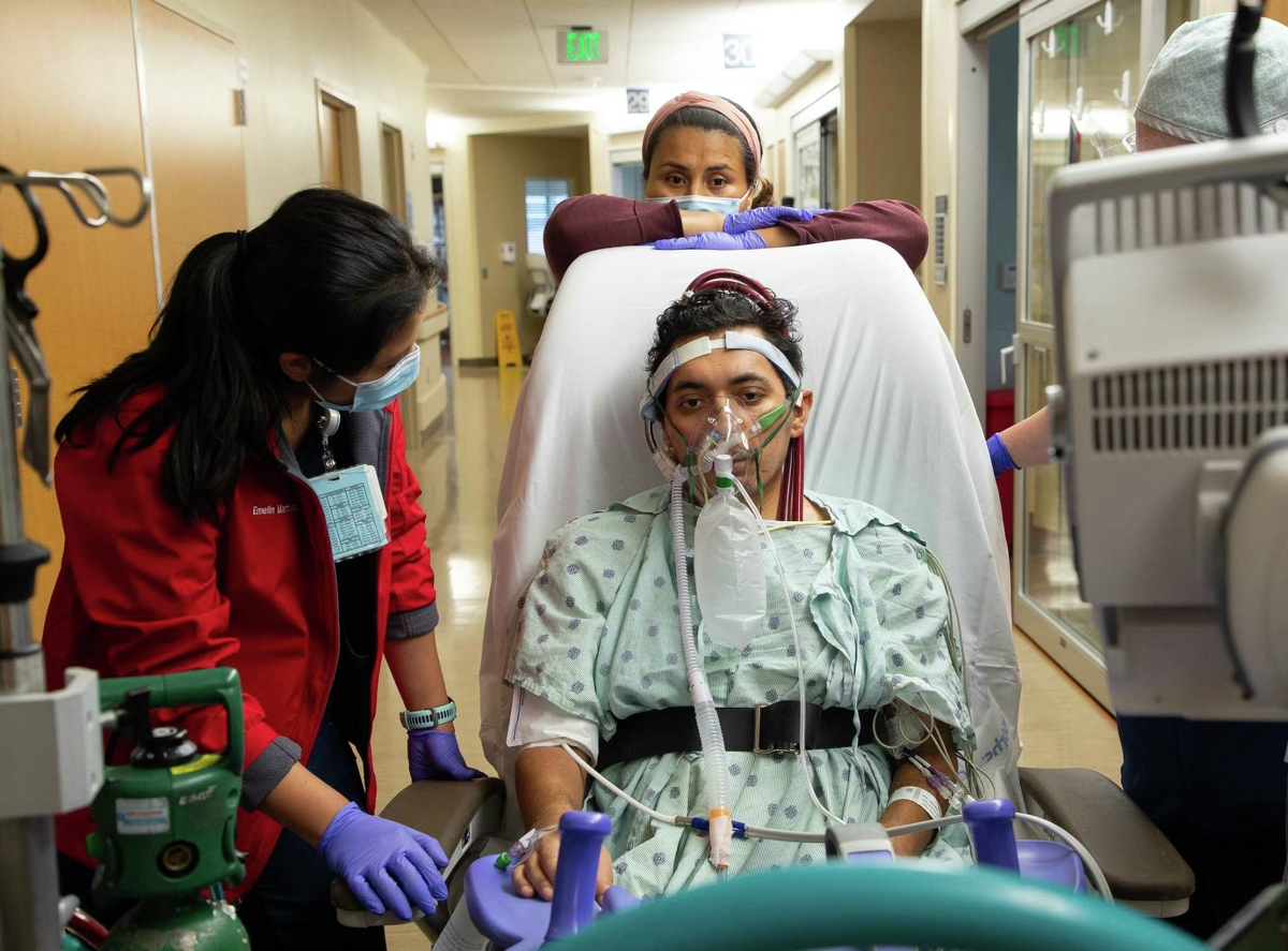 Jesus catches his breath – with the help of an oxygen mask – while taking a brief break from walking. Jesus progresses rapidly with physical therapy, walking farther and farther each day.