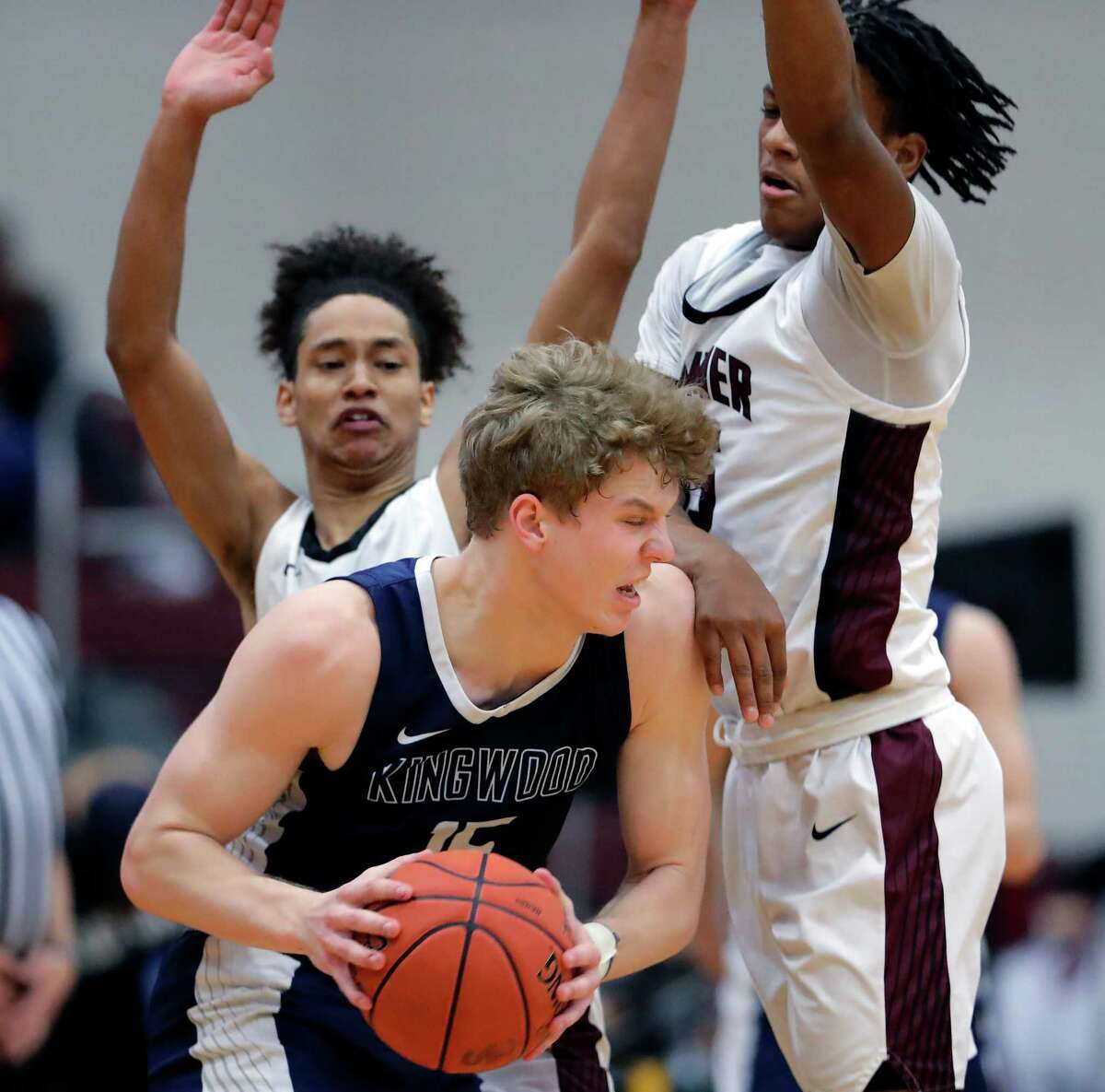 Kingwood’s Tommy Neuman, middle, looks for way around Summer Creek’s Elijah Roman, left, and Corey Nichols, right, during the second half of a high school basketball game Wednesday, Feb. 9, 2022 in Houston, TX.
