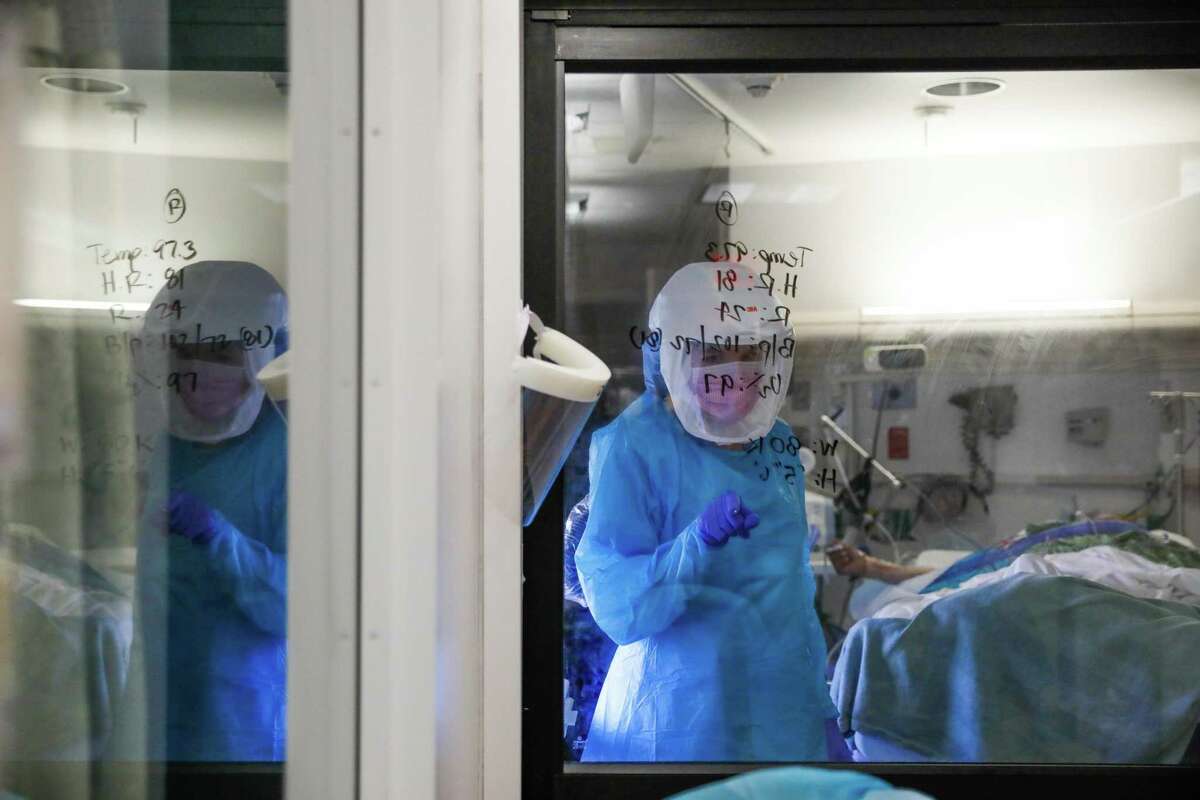 Nurse Kristen Tritt works to help patient Albert Jauregui (right) in a COVID-19 unit at Salinas Valley Memorial Hospital in Salinas, Calif.