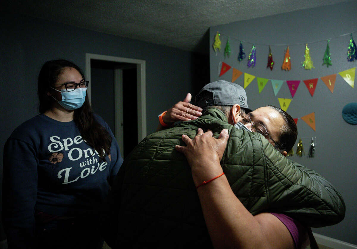Jesus hugs his mom as they arrive at their new in Baytown. The family adorned the wall with a "bienvenido a casa" banner and balloons.