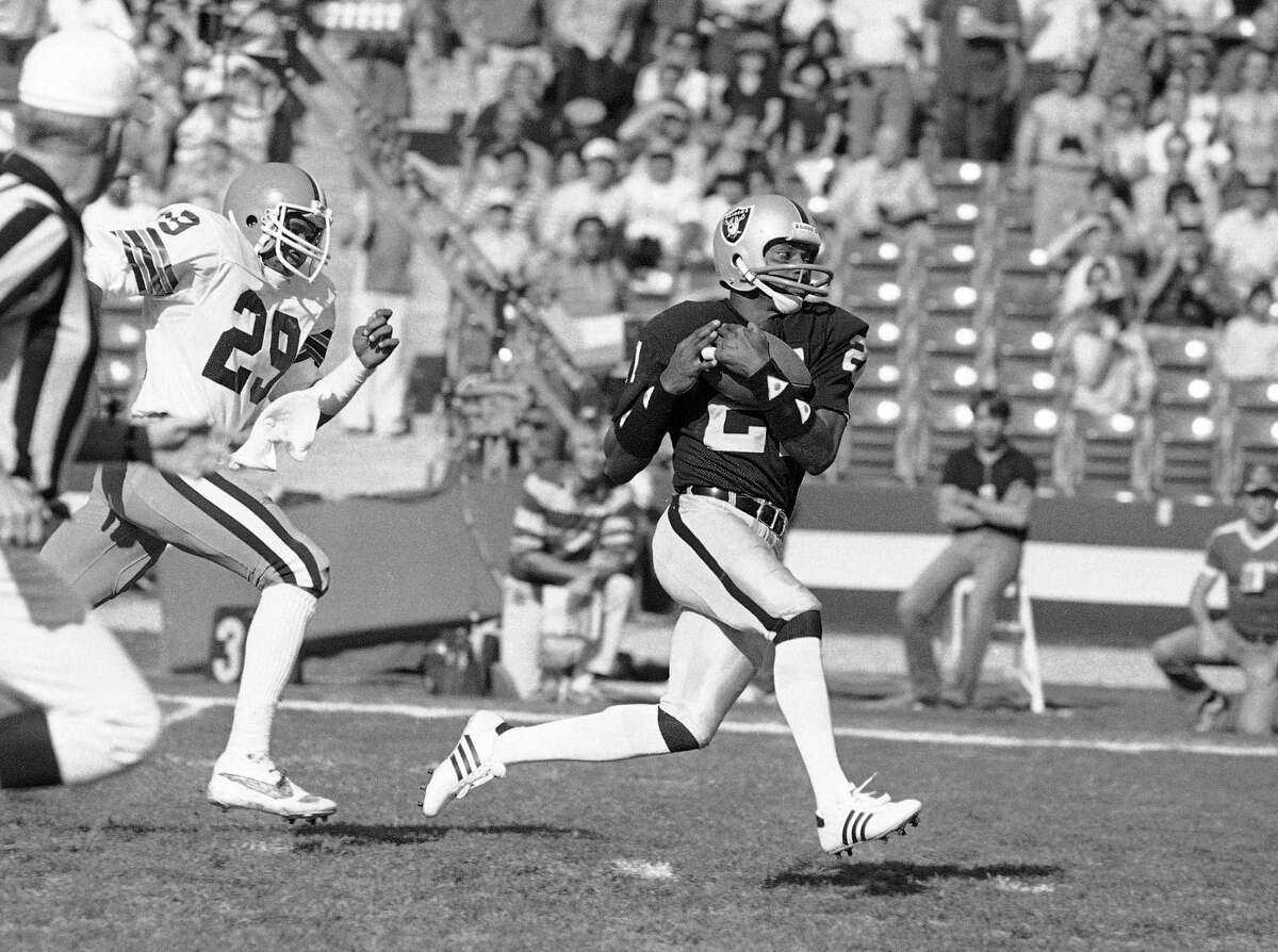 FILE - In this Saturday, Jan. 8, 1983 file photo, Los Angeles Raiders wide receiver Cliff Branch, right, catches a pass from quarterback Jim Plunkett for a 64 yard gain during the first quarter of their playoff game with the Cleveland Browns in Los Angeles. Three-time All-Pro receiver Cliff Branch and Super Bowl-winning coach Dick Vermeil are finalists for the Pro Football Hall of Fame’s class of 2022. (AP Photo/File)