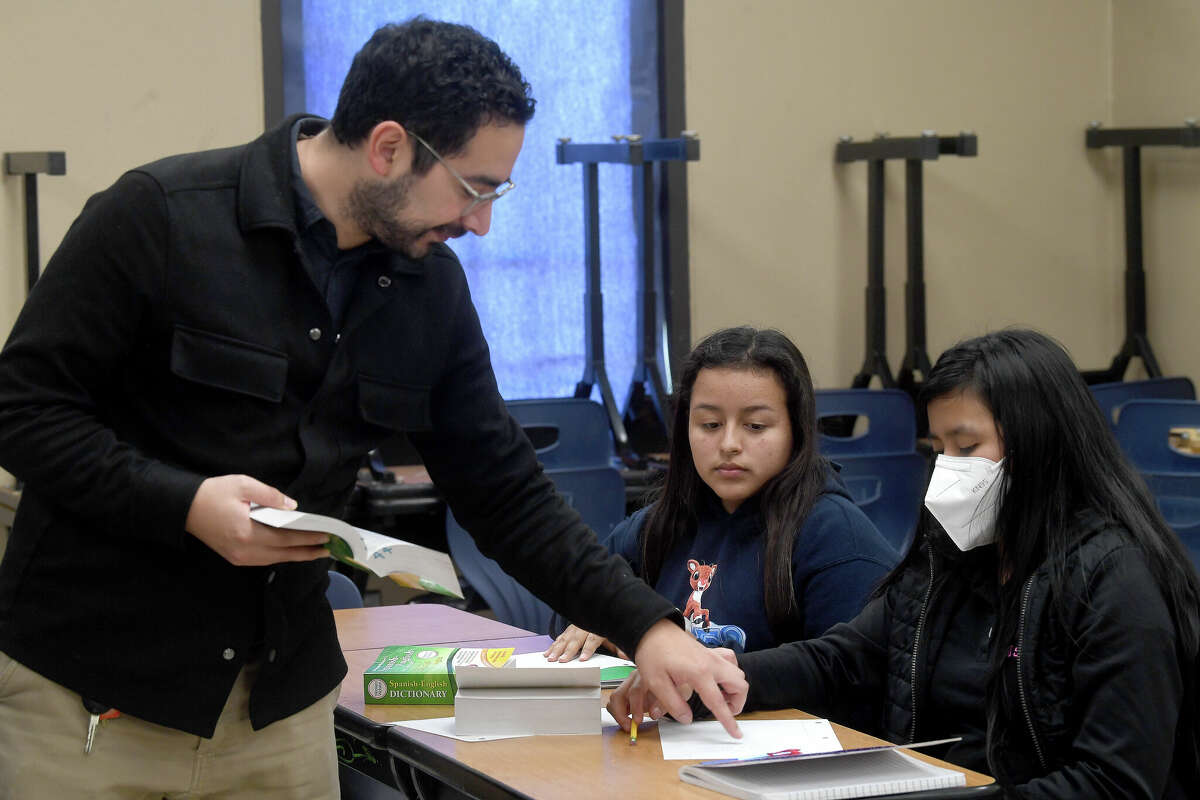 Angel Fernandez instructs students, including Jennifer Blanco and Margarita Batzin, on writing out an assignment during a core class in the new Newcomers Center program, which serves West Brook and Beaumont United students with limited English skills. Photo made Thursday, Feruary 10, 2022 Kim Brent/The Enterprise