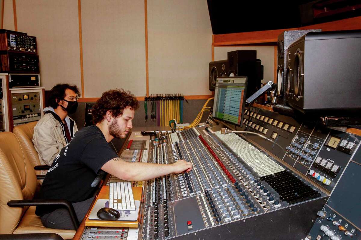 Hyde Street Studios interns Sean Salis (left) and Ely Klem control the record console during a rehearsal.