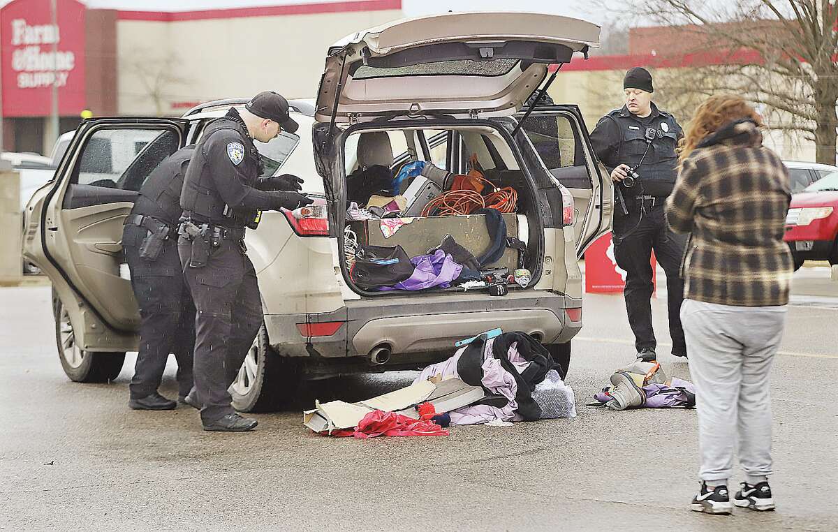 John Badman|The Telegraph Three Alton Police officers searched and photographed the contents of a Ford Escape Friday in front of the Aldi food store, 2822 Homer Adams Parkway, following a report the vehicle's occupants were involved in "suspicious behavior." Police took both occupants of the vehicle into custody but declined to say why. Alton Police Chief Marcos Pulido said events that occurred during the investigation will be presented to the Madison County State's Attorney's Office for potential felony charges.