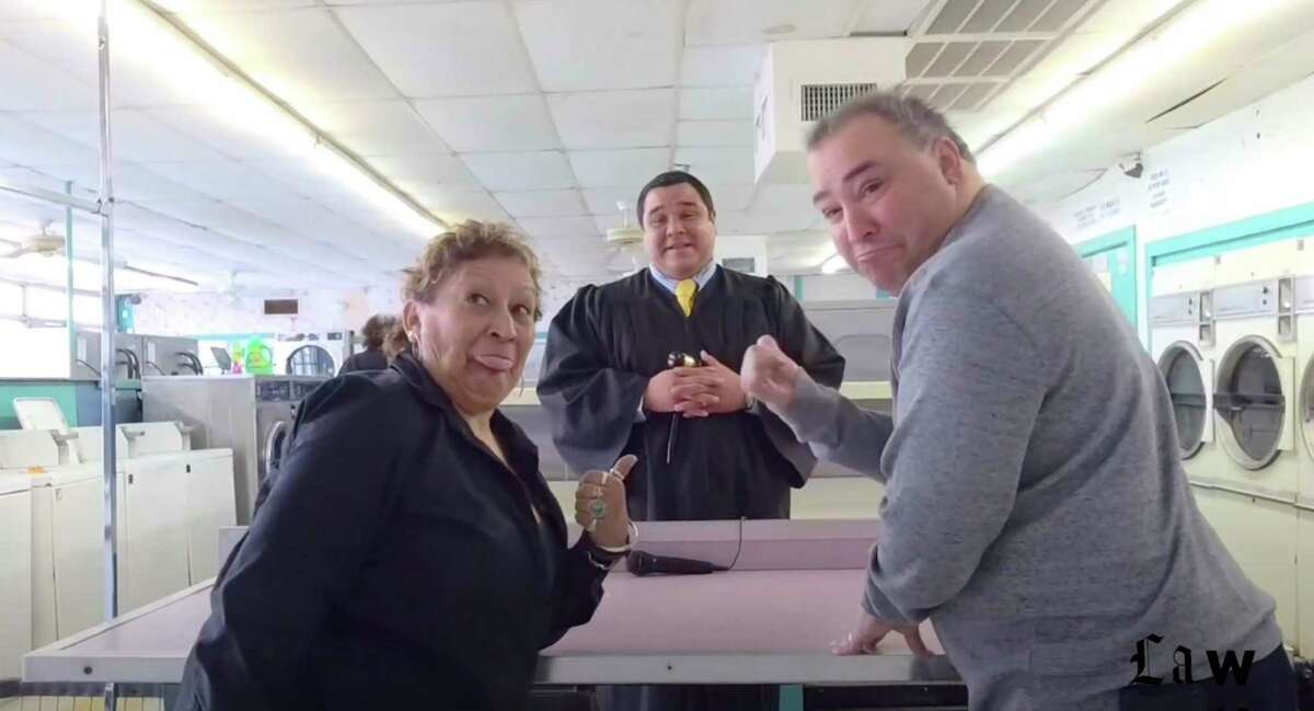State District Judge Carlos Quezada presides over a fictional dispute over a pair of men’s boxer shorts at a trial at a South Side washateria. Critics question the appropriateness of the YouTube video, designed to boost his re-election campaign for the 289th Juvenile District Court.