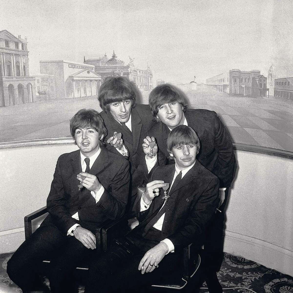 LONDON - OCTOBER 26: (Clockwise) English singer, songwriter and guitarist George Harrison (1943-2001), English singer, songwriter and guitarist John Lennon (1940-1980), English singer, songwriter and drummer Ringo Starr and English singer, songwriter and bassist Paul McCartney of the Beatles display their MBE medals at Buckingham Palace on October 26, 1965, in London, United Kingdom. (Photo by Jeff Hochberg/Getty Images)