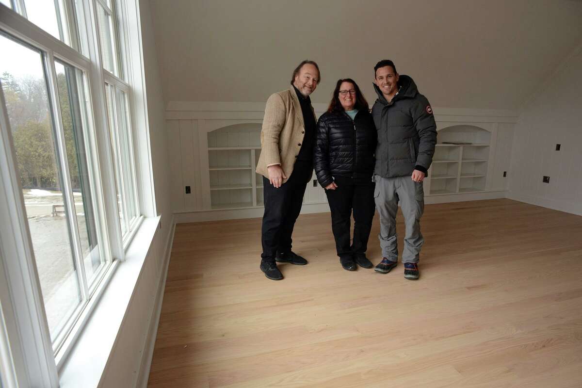 Homeowner Amy Macey poses with architect Duo Dickinso, left, and developer Adam Greenberg in the master bedroom of her new home under construction in the General’s Residence development in Madison, Conn. Feb. 7, 2022.