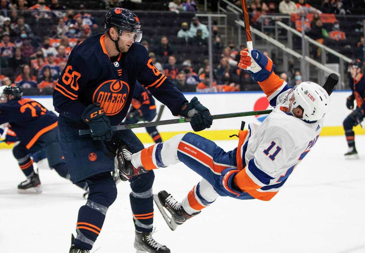 New York Islanders' Zach Parise (11) is checked by Edmonton Oilers' Markus Niemelainen (80) during the first period of an NHL hockey game Friday, Feb. 11, 2022, in Edmonton, Alberta. (Jason Franson/The Canadian Press via AP)