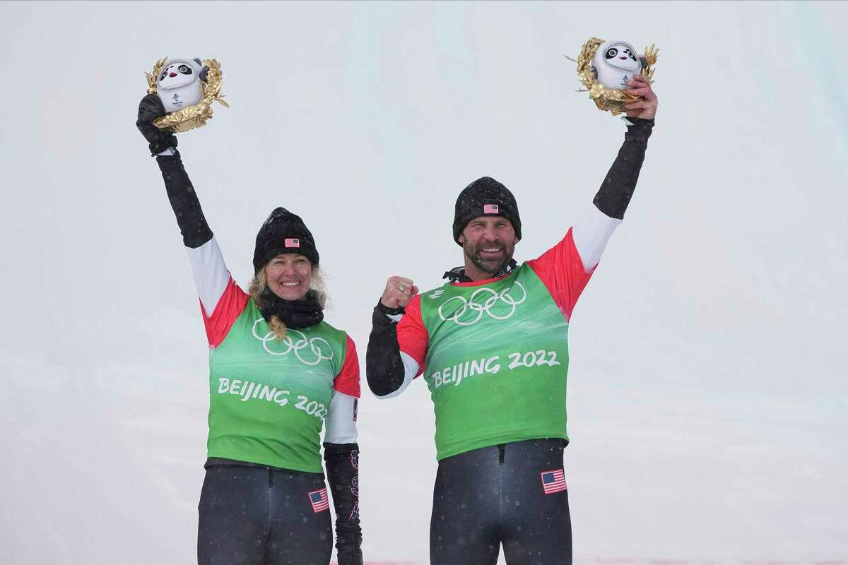 Gold medal winners United States' Lindsey Jacobellis and Nick Baumgartner celebrate during the venue award ceremony for the mixed team snowboard cross finals at the 2022 Winter Olympics, Saturday, Feb. 12, 2022, in Zhangjiakou, China. (AP Photo/Gregory Bull)