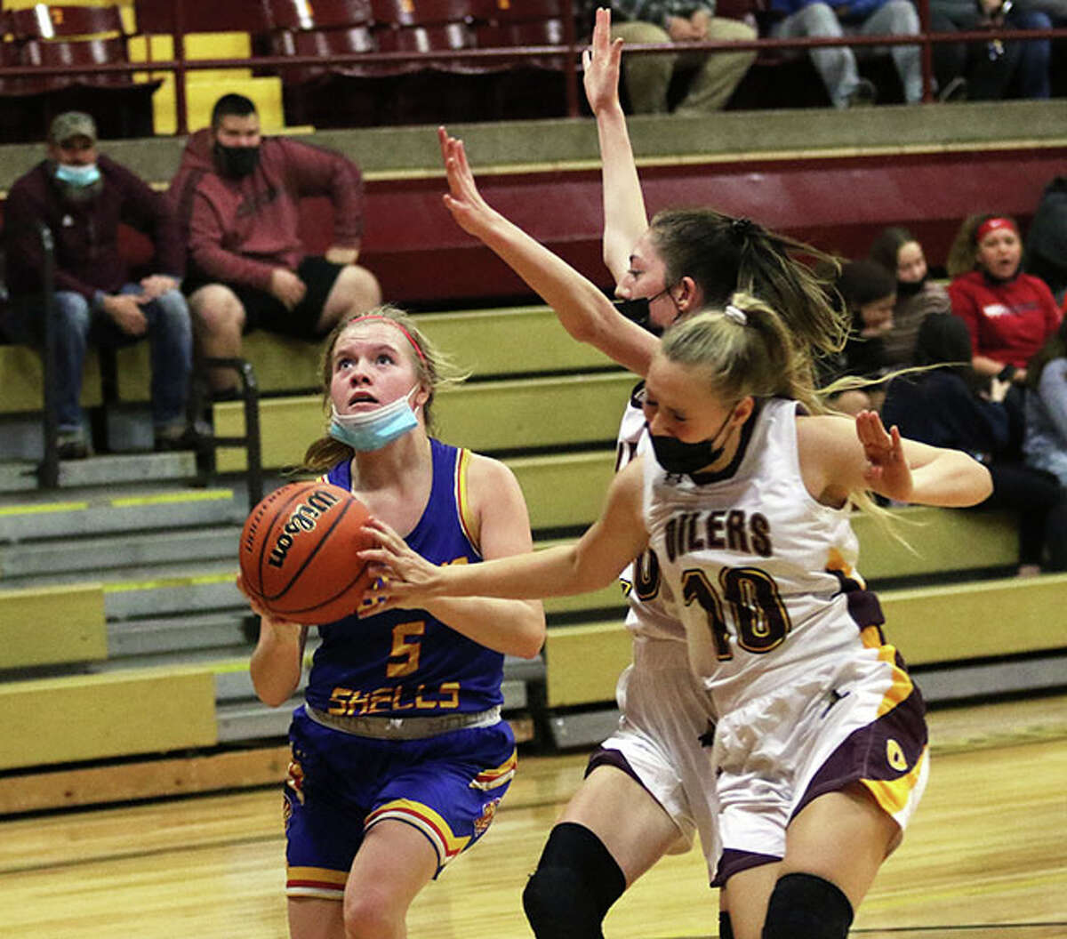Roxana's Lexi Ryan (left) takes the ball to the basket to score while EA-WR's Ocean Bland (10) and Makayla Quigley contest the shot in a Shells win when teams met Dec. 15 in Wood River. The rivals played for the fourth time this season on Friday night, with the Oilers winning in Roxana. 
