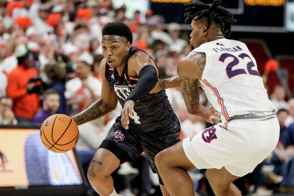 Texas A&M guard Wade Taylor IV (4) drives to the basket around Auburn guard Allen Flanigan (22) during the first half of an NCAA college basketball game Saturday, Feb. 12, 2022, in Auburn, Ala. (AP Photo/Butch Dill)
