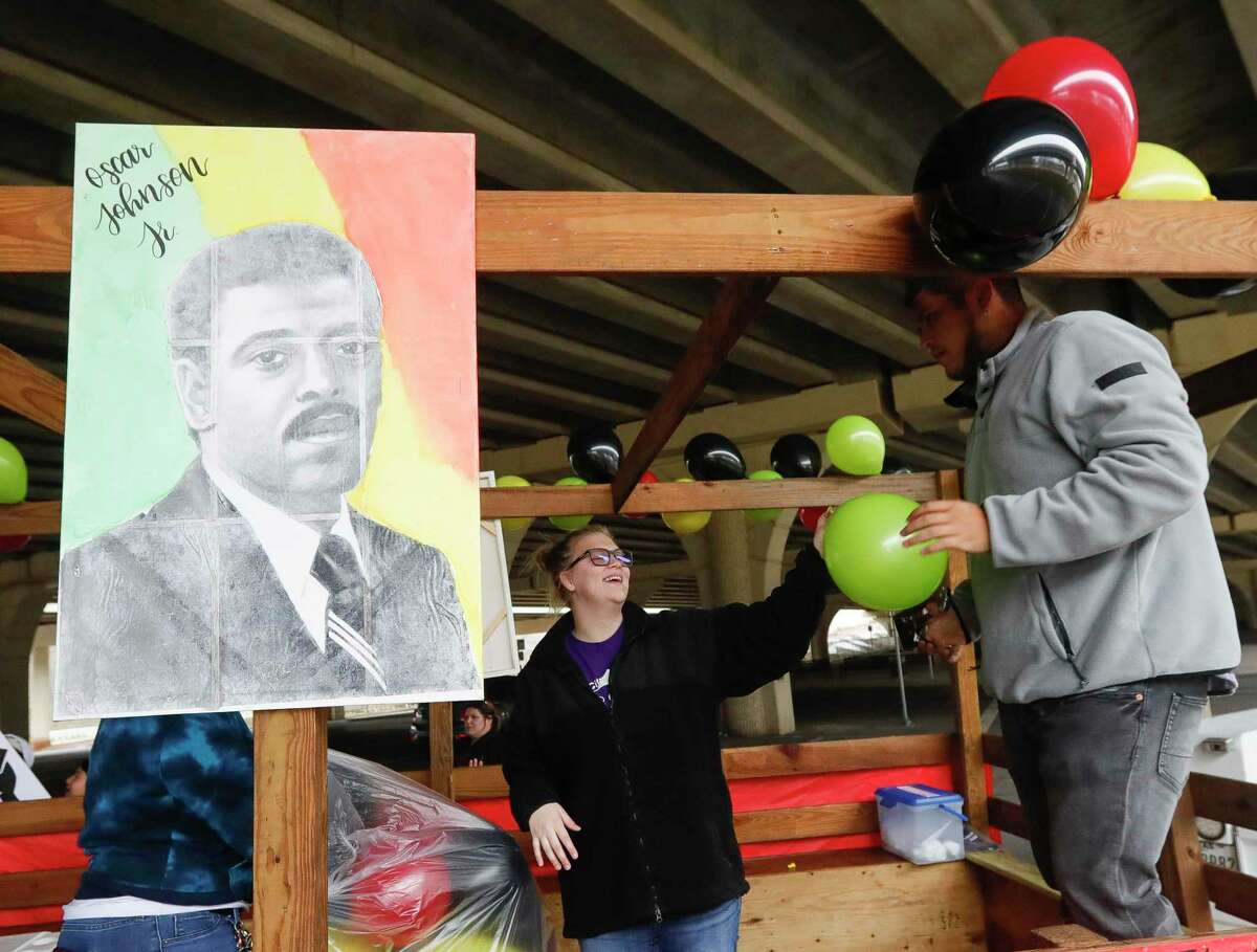 Natalie Watkins, center hands Antonio Luna a balloon as they prepare a float in honor of Oscar Johnson Jr., the Conroe’s first black city councilman, and other historic figures for the city’s annual Black History Month parade, Saturday, Feb. 12, 2022, in Conroe.